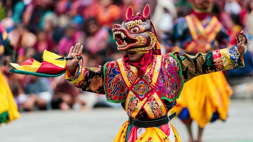 Colorful masked dancers in traditional attire